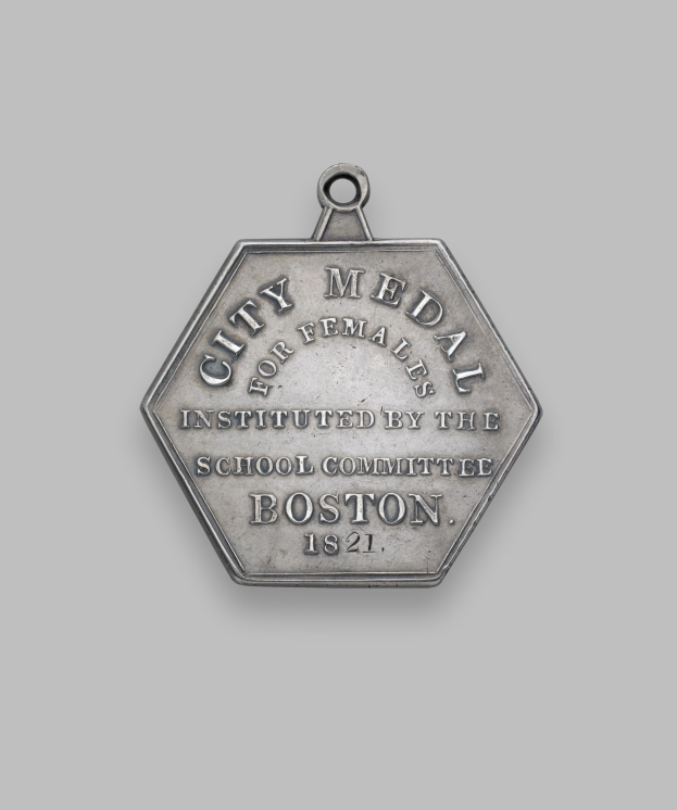 Eine silberne Medaille mit der Inschrift 'Stadtmedaille für Frauen' vor einem weißen Hintergrund.