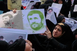 Eine Gruppe iranischer Frauen in schwarzer Kleidung, einige tragen Brillen, halten Fotos von Präsident Mahmoud Ahmadinejad während einer Demonstration in Tehran hoch.