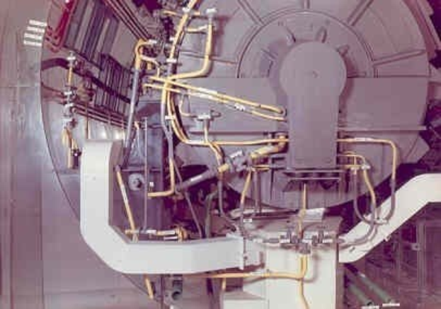 Großes industrielles Accelerator-Maschinen mit mehreren verbundenen Komponenten und Kabeln innerhalb eines Gebäudes.