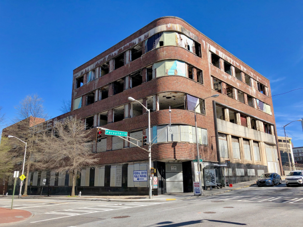 Altes Backsteingebäude mit der Aufschrift "Fortythia Medical Center" an einer Straßenecke, jetzt abgerissen, mit umgebender Straßeninfrastruktur und Fahrzeugen.