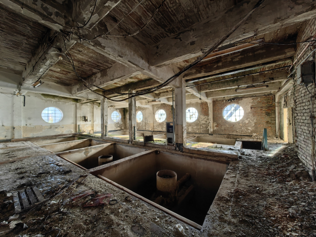 Verlassenes Gebäude-Innenraum im Chernobyl-Ausschlussgebiet mit verstreuten Trümmern, freiliegenden Wänden, Decke und strukturellen Elementen.